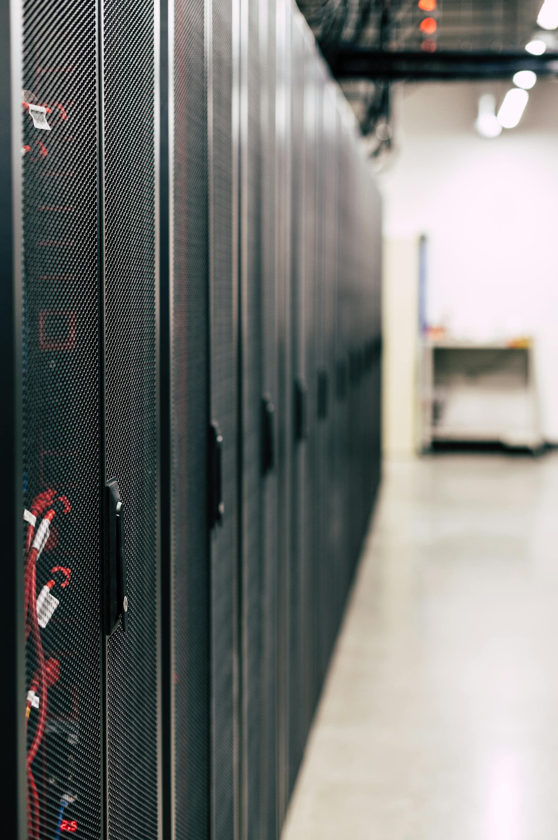 Server racks lit with red wiring and indicator lights — evoking the speed at which an unsupervised AI agent can wipe production data.