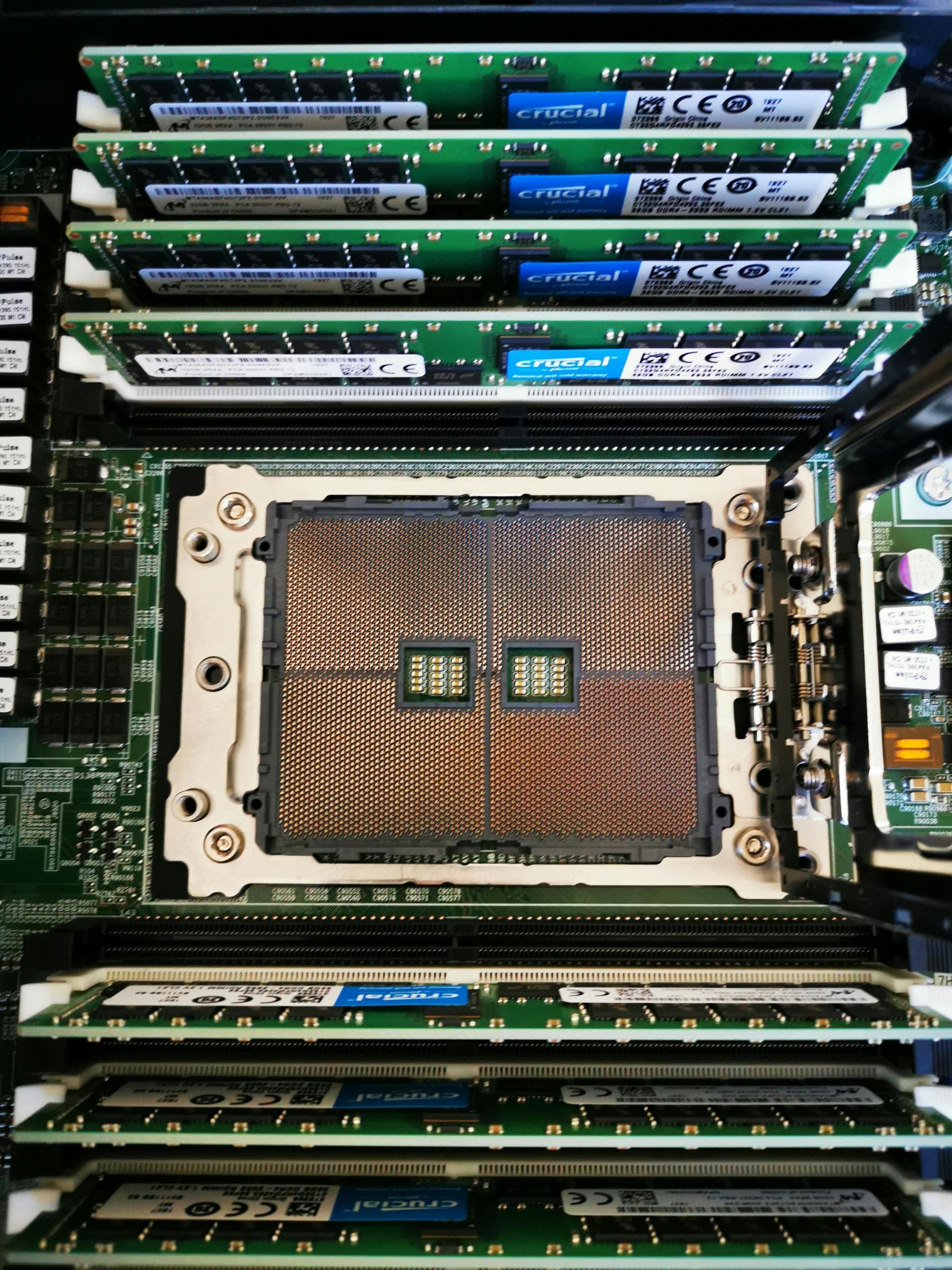 Close-up of populated DIMM slots and CPU socket on a server motherboard — the contents of those slots is where the entire 2026 server price story lives.